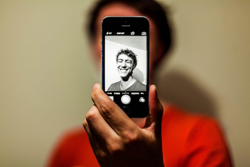 a man taking a black-and-white selfie , smile, red t-shirt,, antoine beauvillain